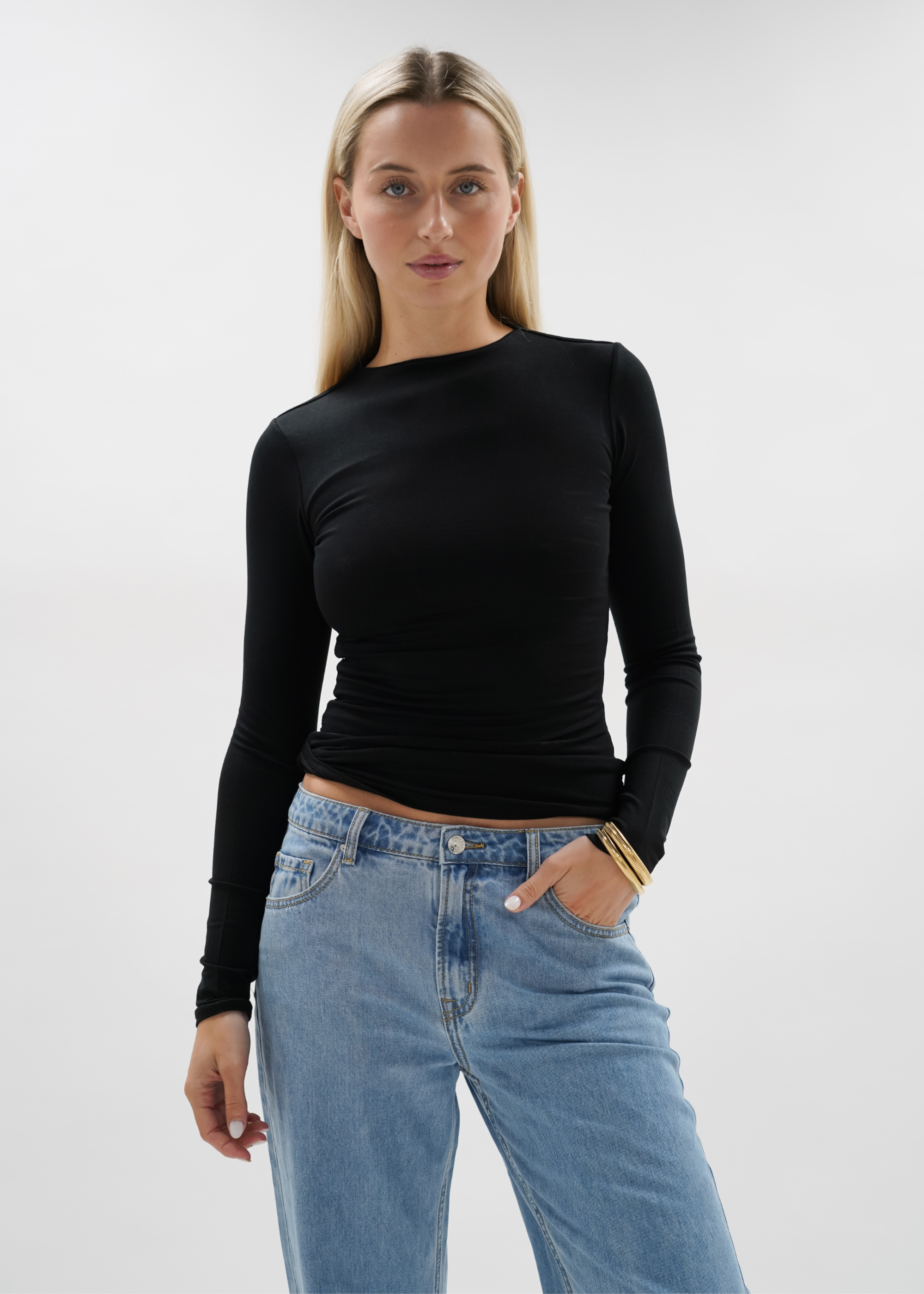 Woman wearing a black top against a plain background
