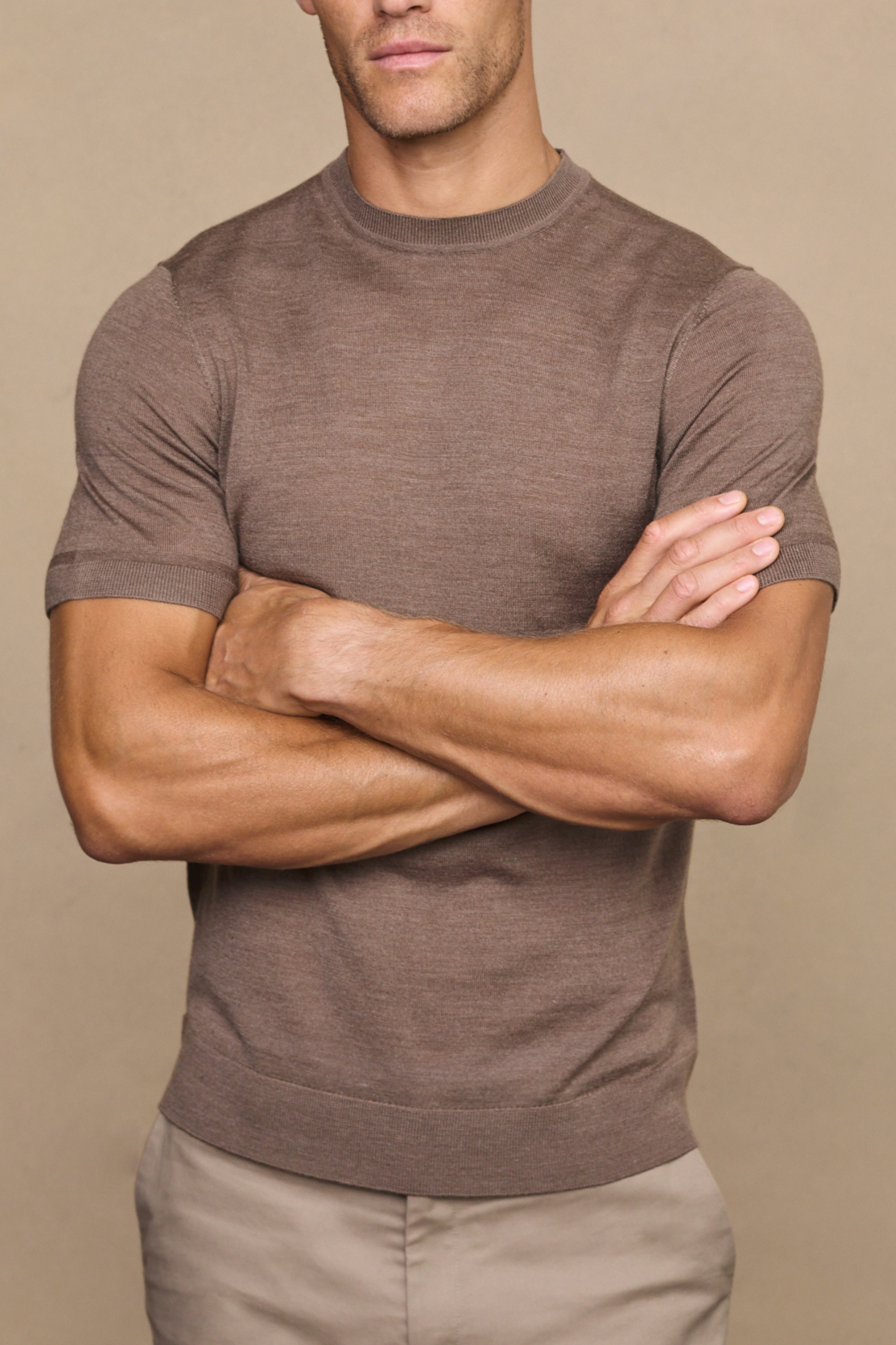 Man wearing a cedric brown marl fine knit t-shirt against a plain white background