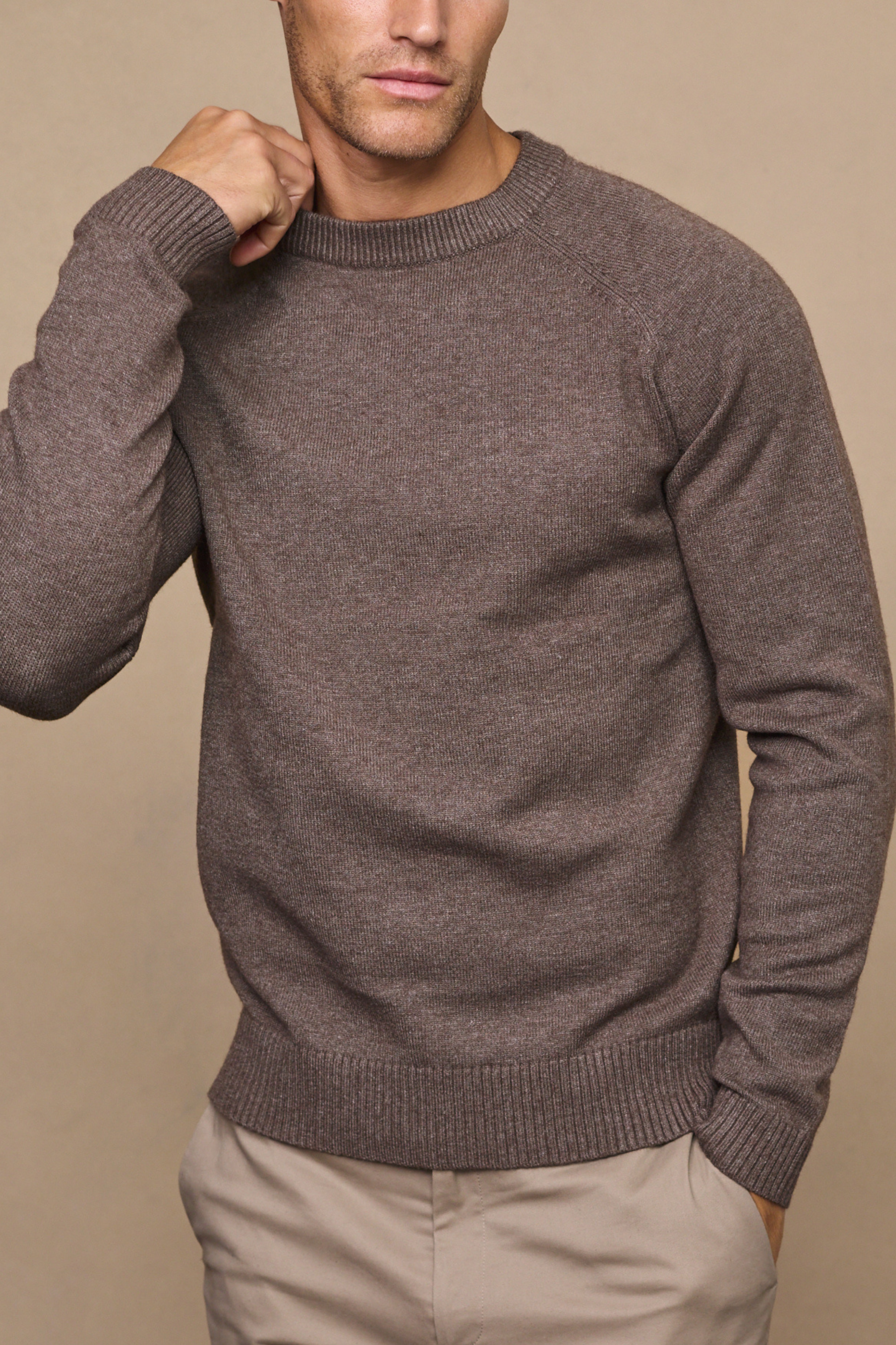 Man wearing a lando brown marl crew neck knit sweater against a light beige background