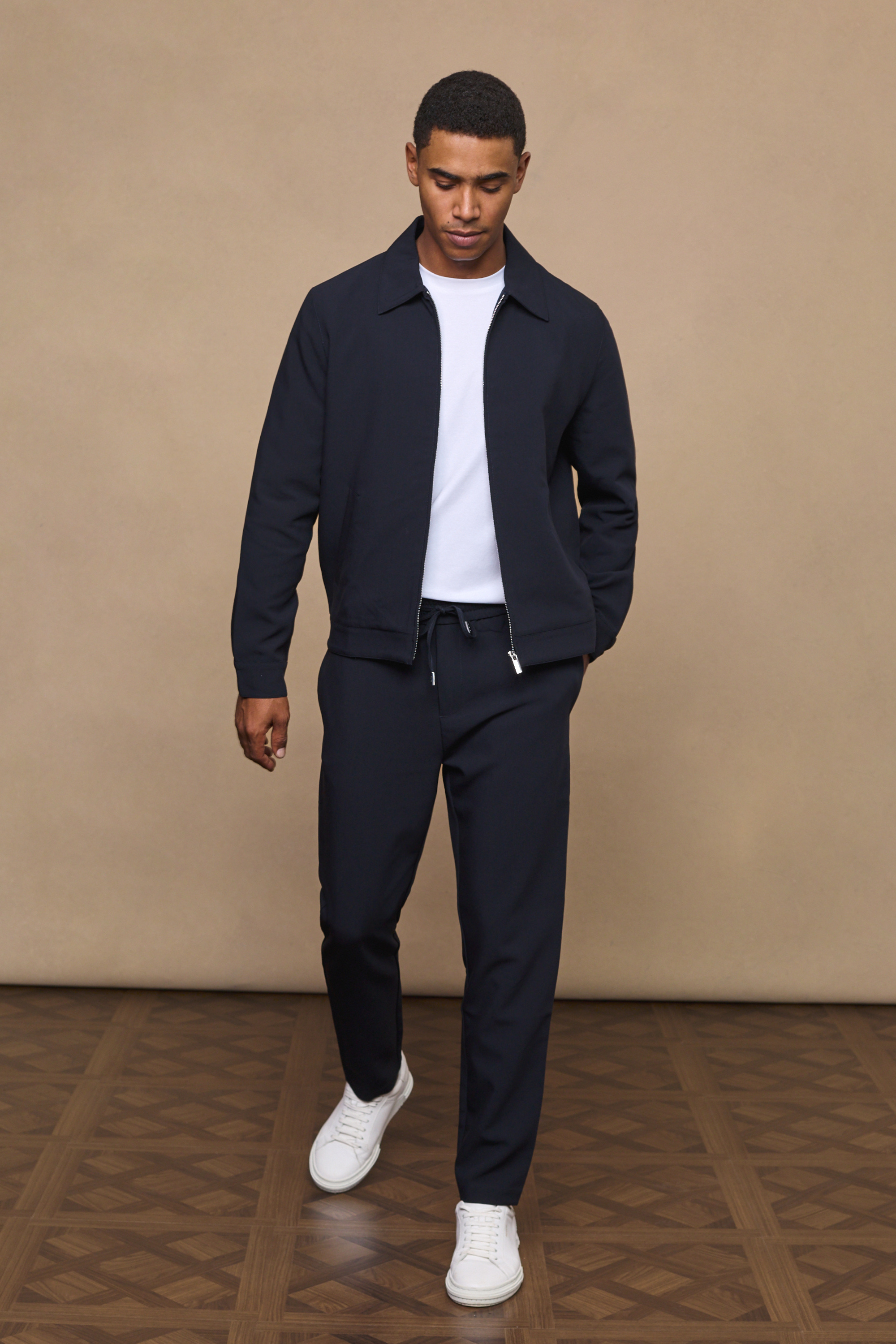 Man wearing an emilio dark navy zip-up jacket against a clean white background