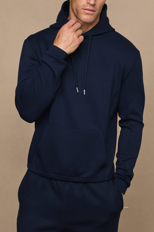 Man wearing a navy luxe hoodie against a plain background