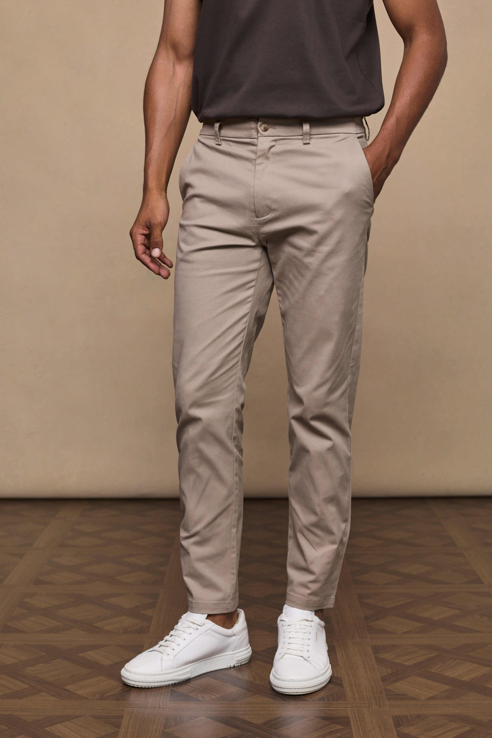 Man wearing a beige chinos against a clean background
