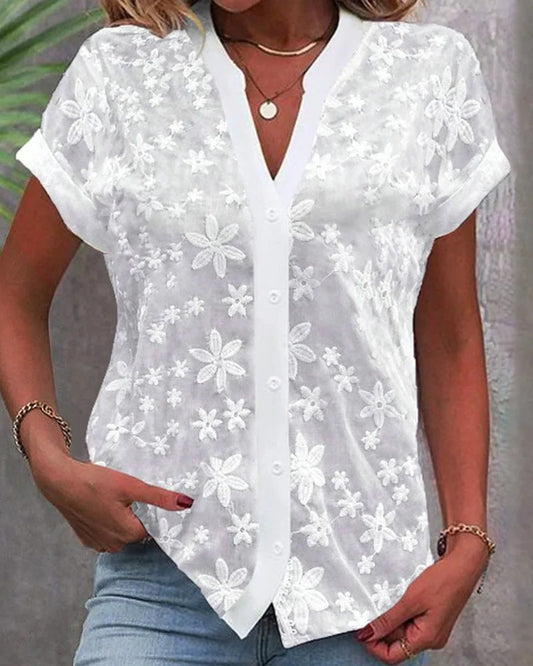 Woman wearing an elise | v-neck short sleeve blouse against a clean background