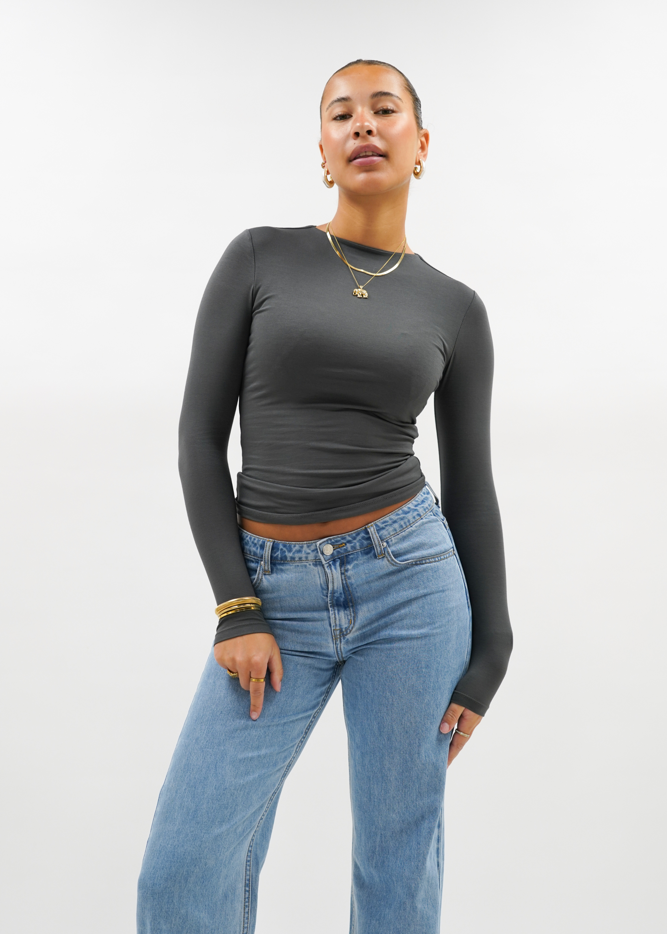 Woman wearing a charcoal top against a plain background