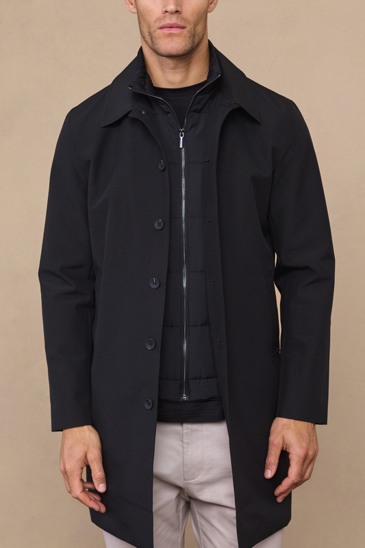 Man wearing a black portico trench coat with removable insert against a neutral studio background