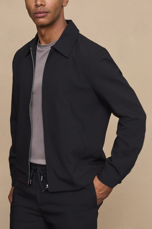 Man wearing a black emilio zip-up jacket against a clean white background