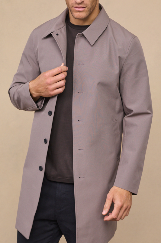 Man wearing a mushroom portica trench coat against a neutral studio background