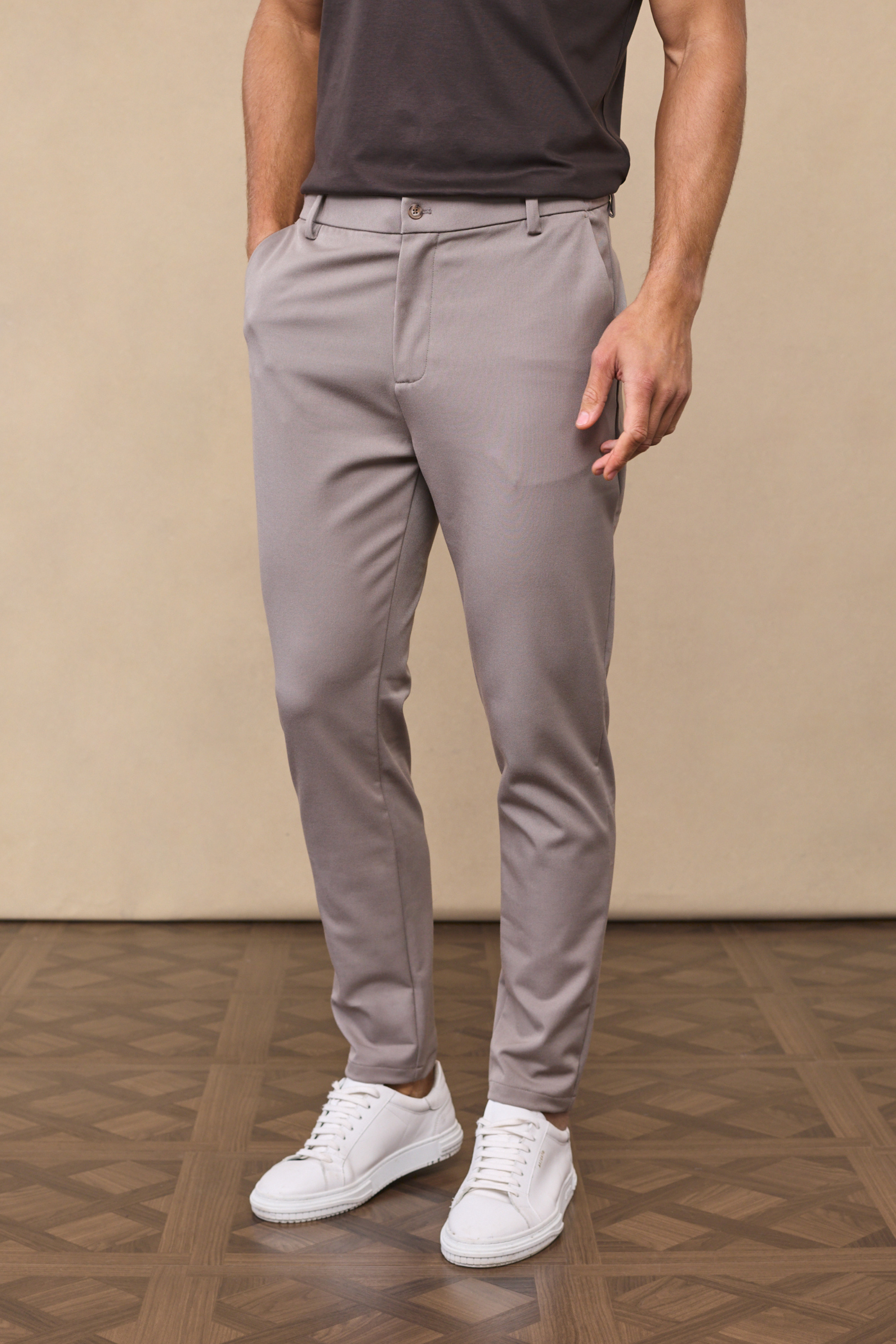 Man wearing a hugo everyday tapered pants - warm grey against a clean background