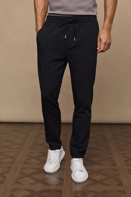 Man wearing an emilio classic black tapered trousers against a plain background