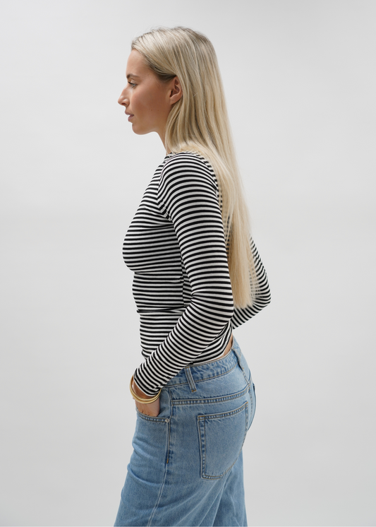 Woman wearing a striped top against a plain background