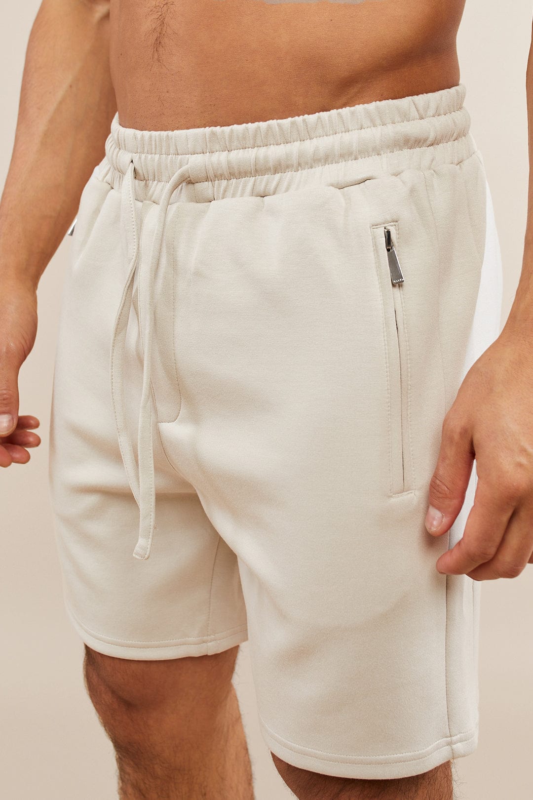 Man wearing a neoprene shorts - stone against a plain background