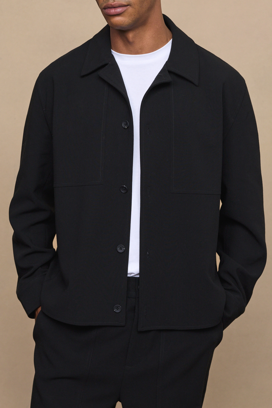 Man wearing a black julien relaxed panel jacket against a clean white background