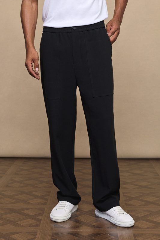 Man wearing a julien black relaxed panel trousers against a plain background