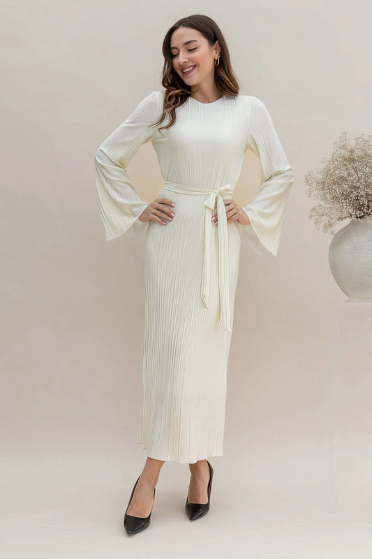 Woman wearing a pleated midi dress against a clean studio background