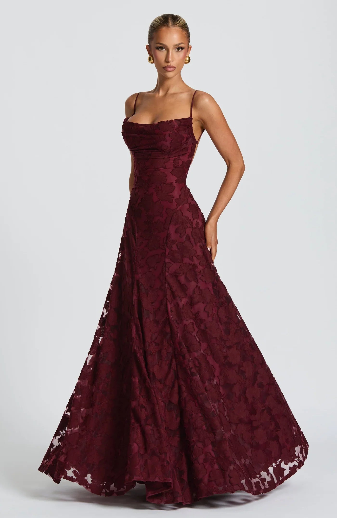 Woman wearing a maxi gown against a clean studio background
