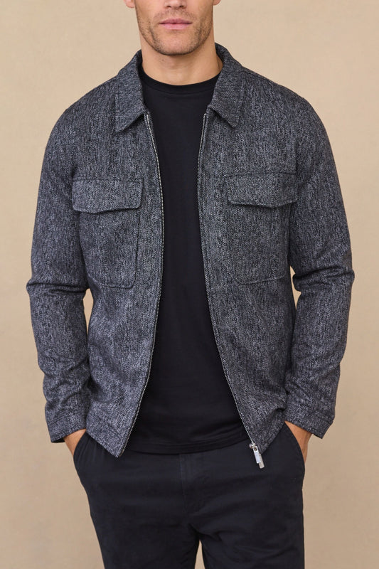 Man wearing a carter black herringbone wool harrington jacket against a clean white background