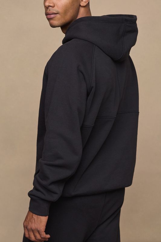 Man wearing a black axel relaxed fit panelled hoodie against a plain background