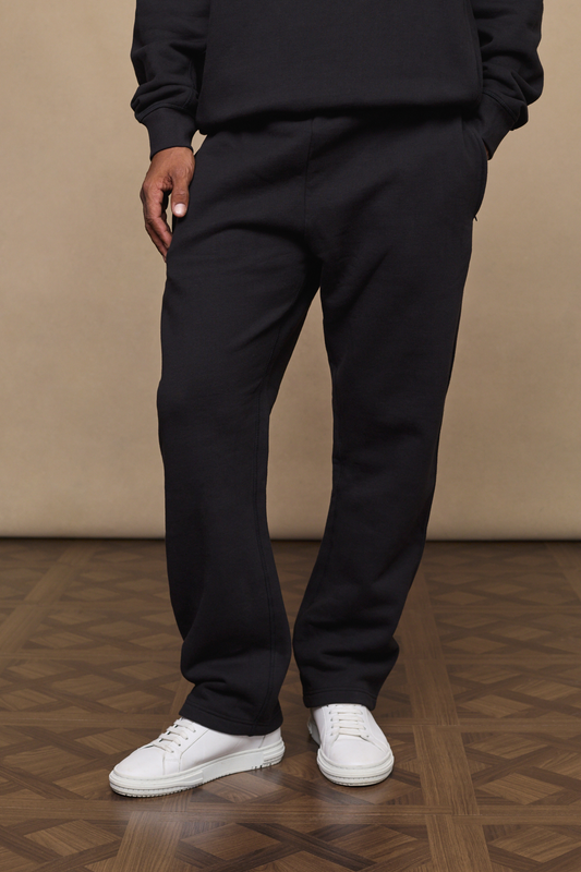 Man wearing a black axel straight leg joggers against a minimal background