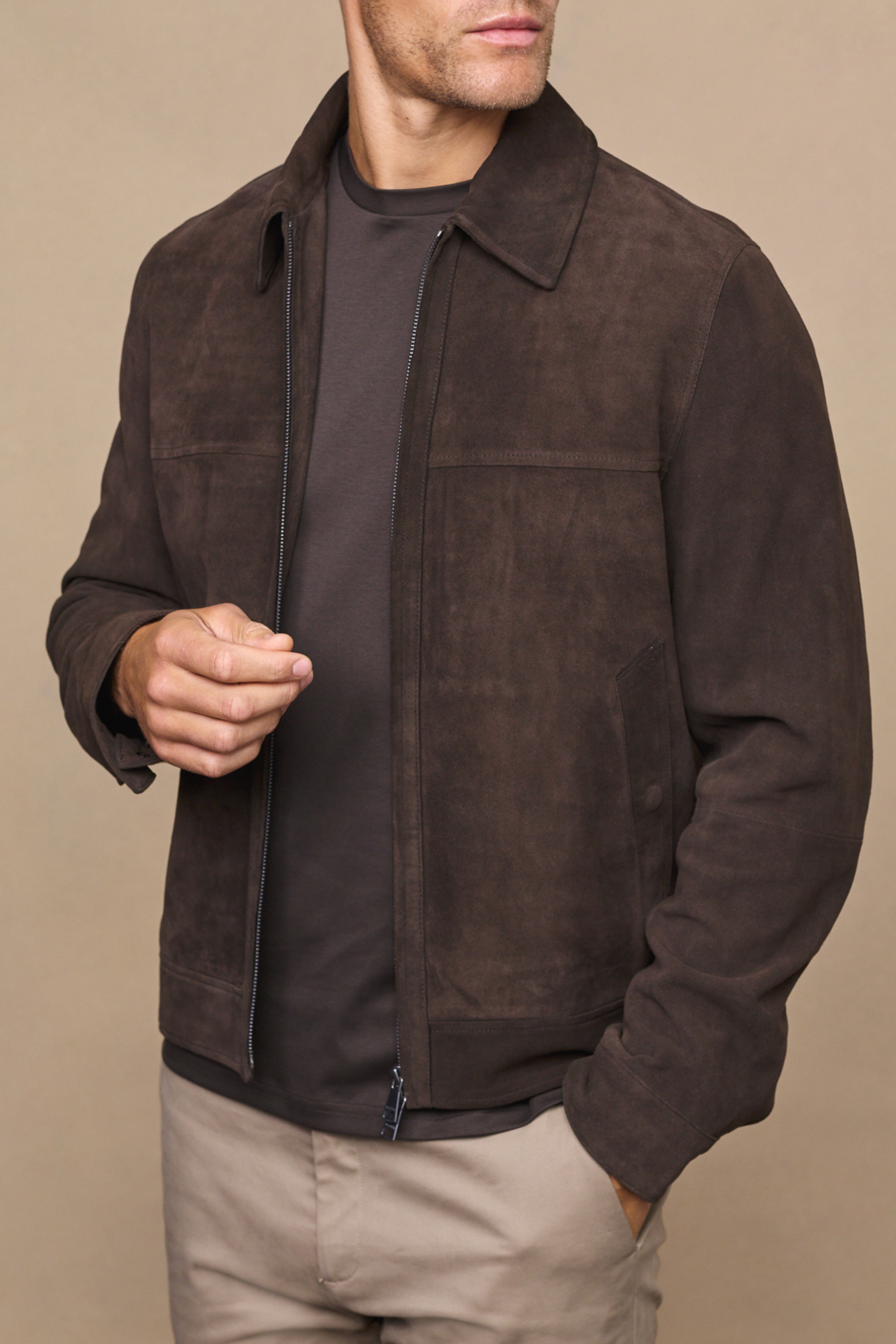 Man wearing a brown suede bruno jacket against a clean white background
