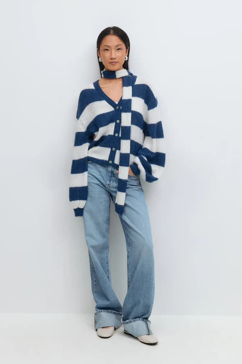 Woman wearing a striped cardigan against a soft neutral background