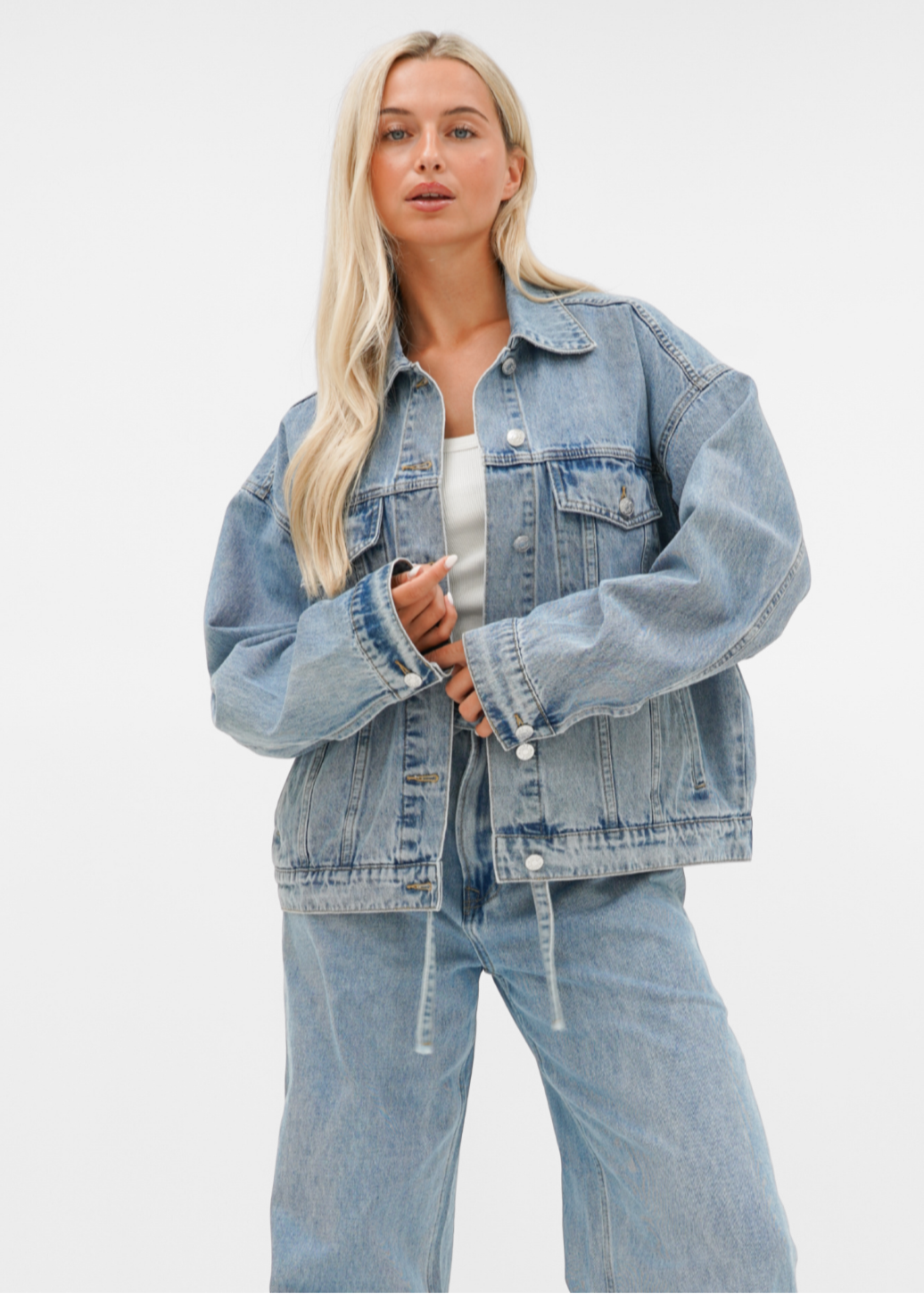 Woman wearing a blue denim jacket against a clean white background