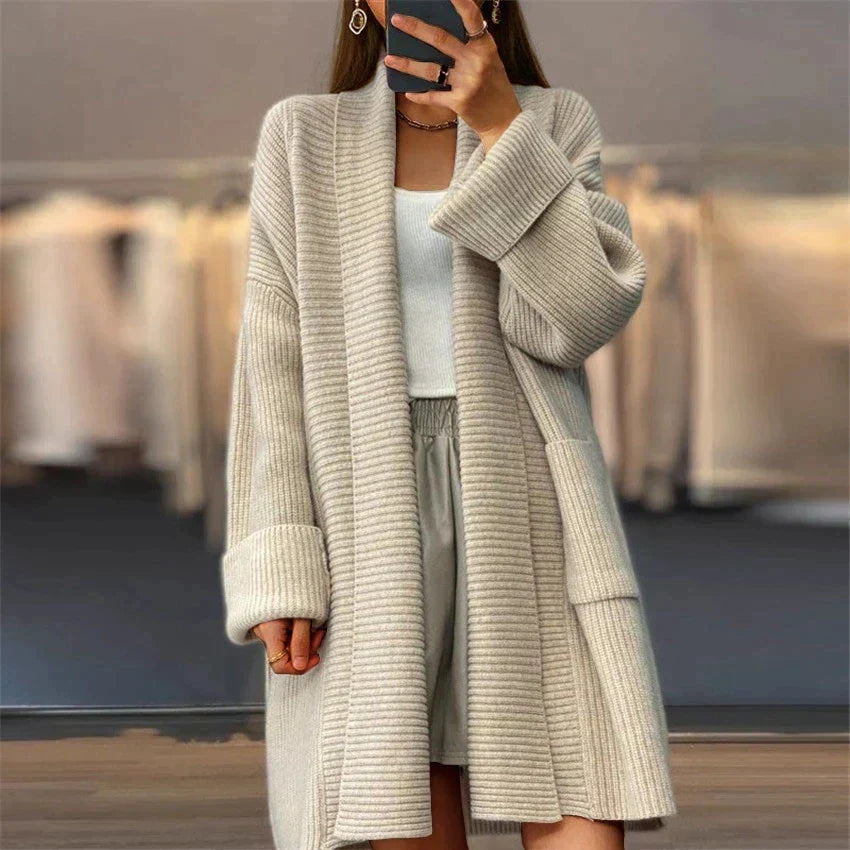 Woman wearing an euphemia long knit cardigan - cozy oversized fit against a soft neutral background