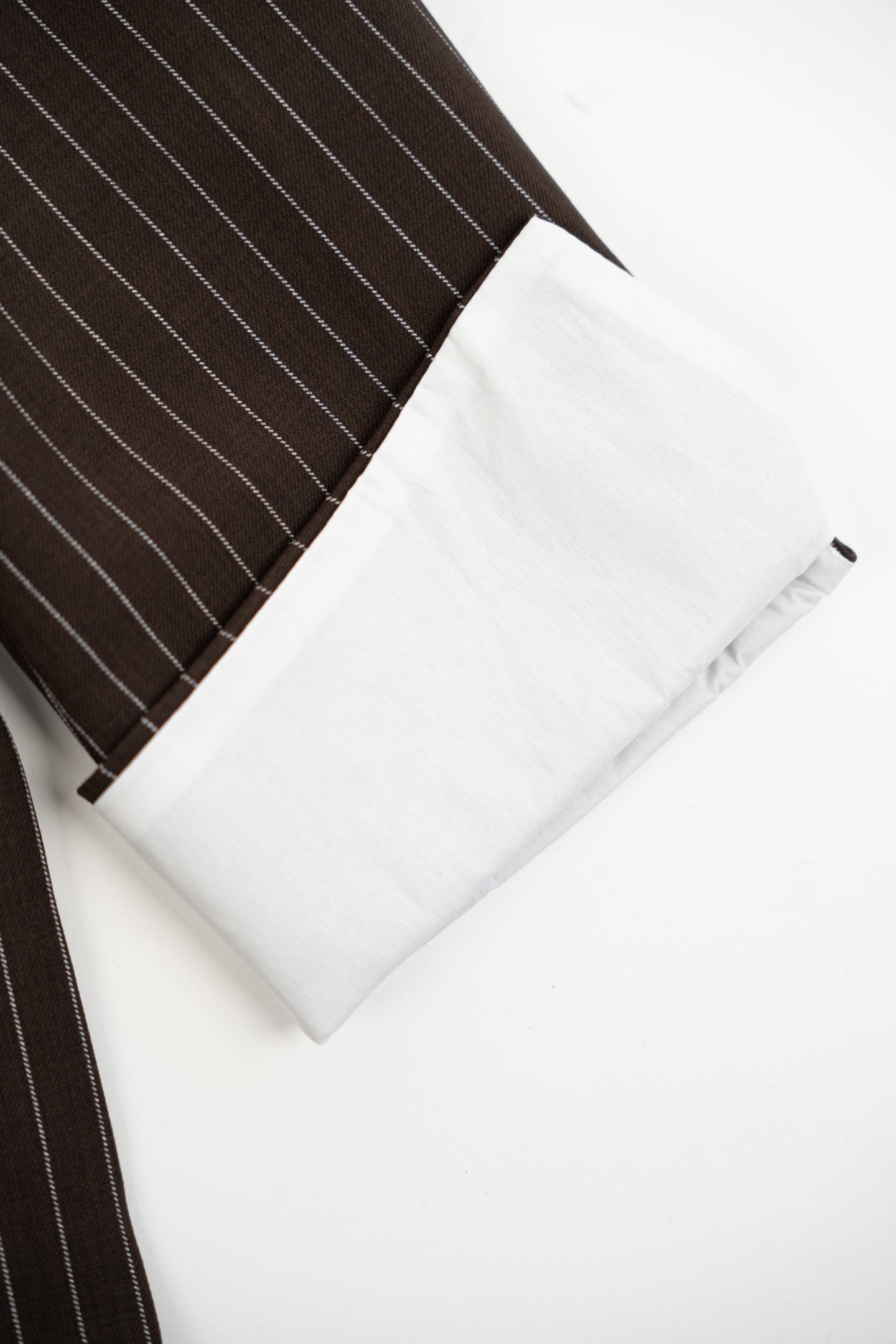 White pouch with a black strap on a white background