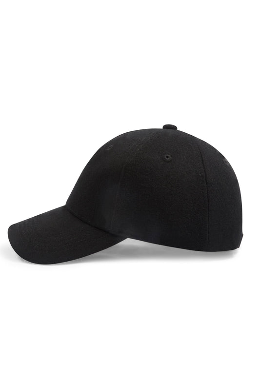 Man wearing a black wool beanie against a clean background