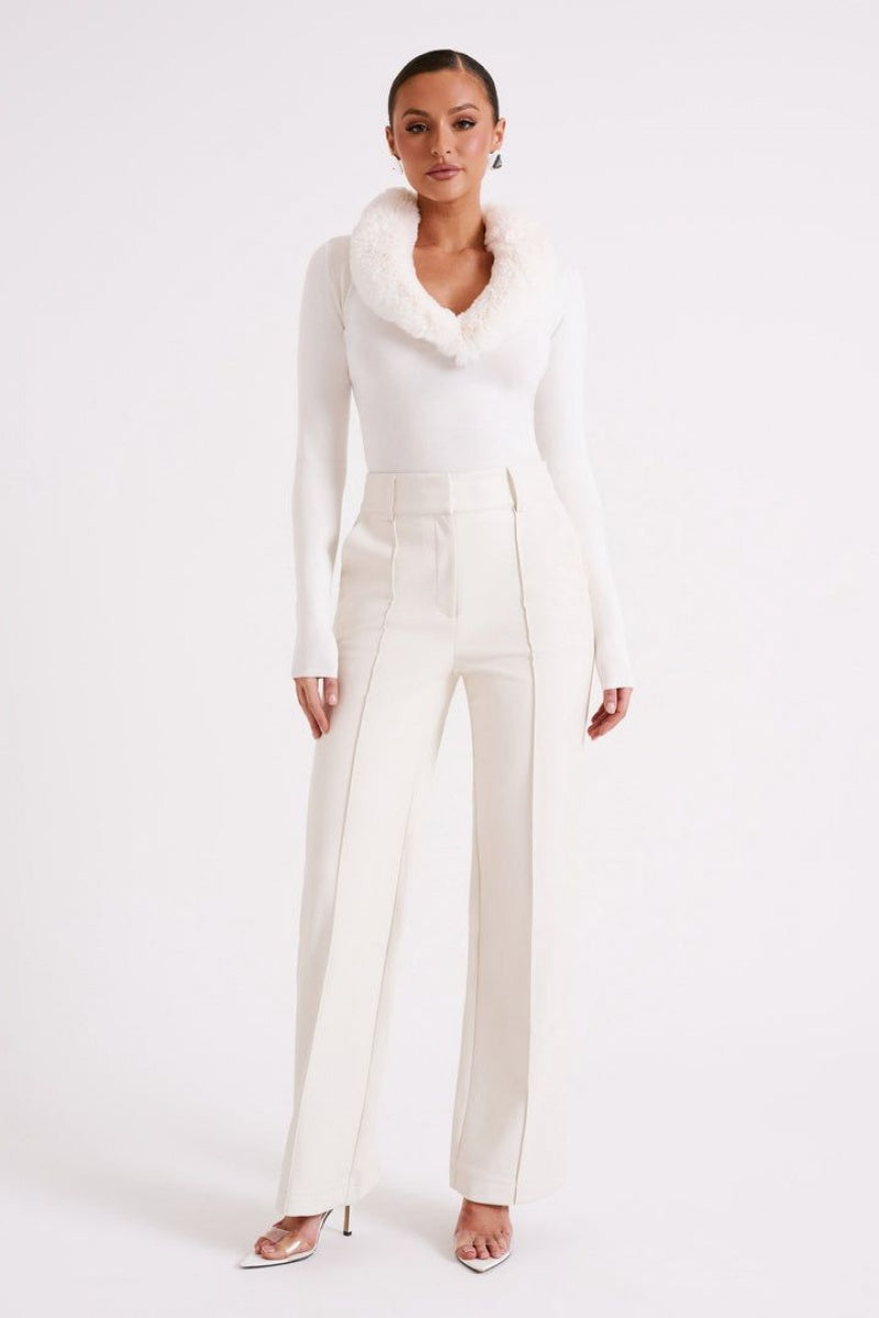 Woman wearing a trousers against a plain background