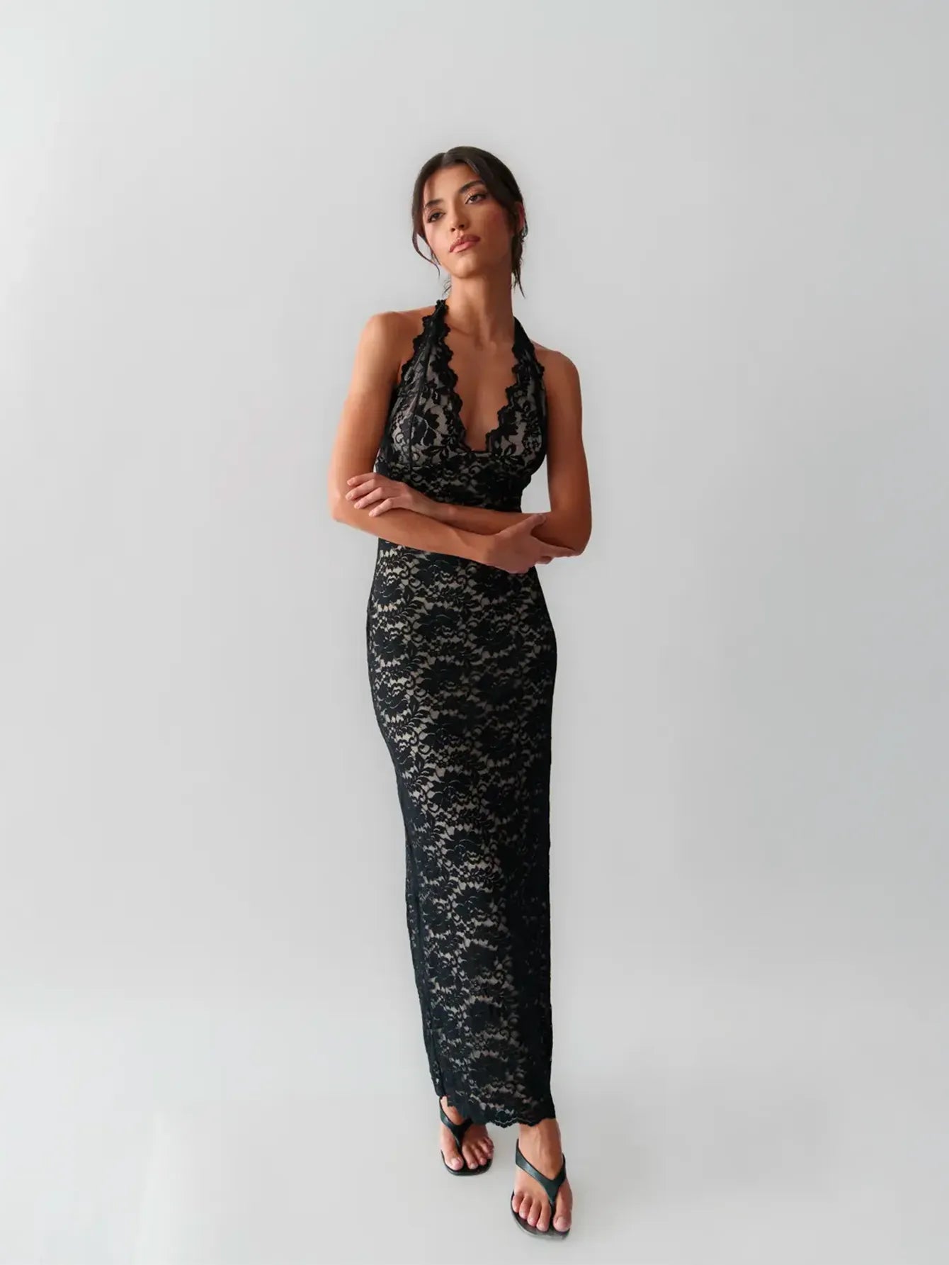 Woman wearing a lace gown against a clean studio background