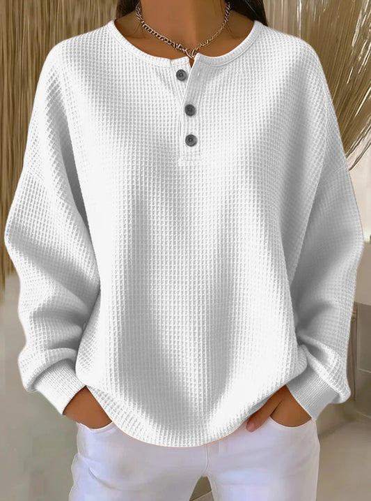 Woman wearing a sweater against a light beige background