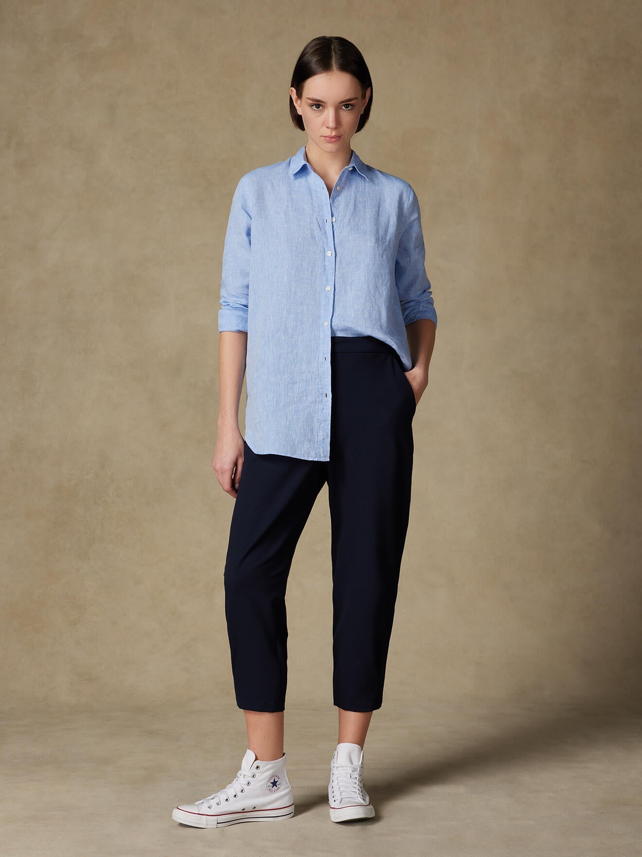 Woman wearing a linen shirt against a clean background