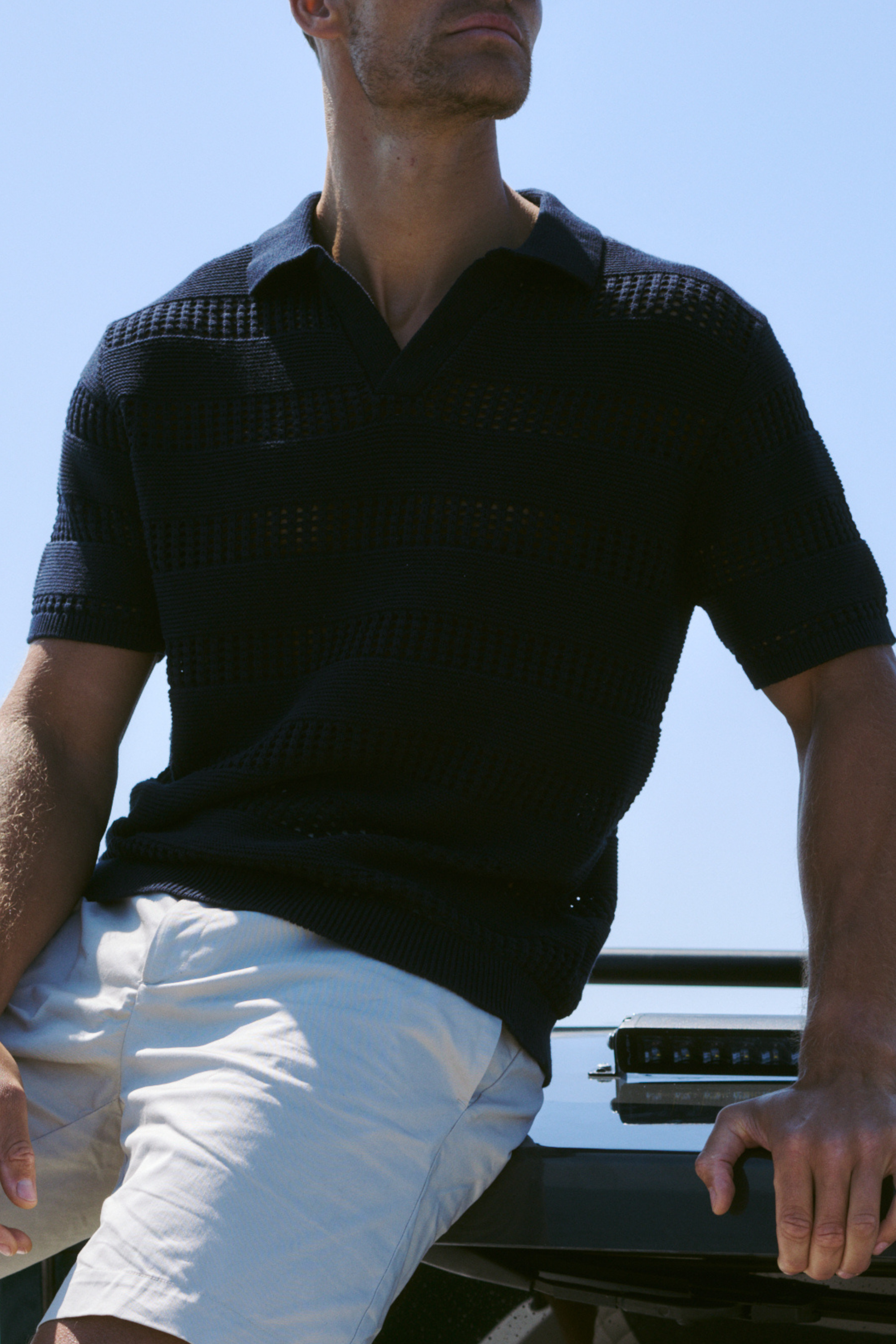 Man wearing a navy frattina crochet cotton knit polo against a clean background