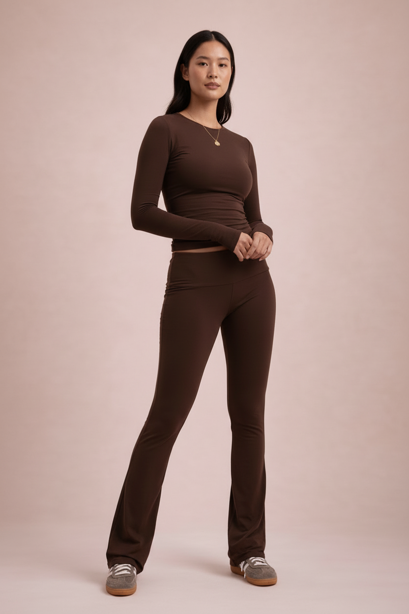 Woman wearing a brown long-sleeve top and pants on a beige background