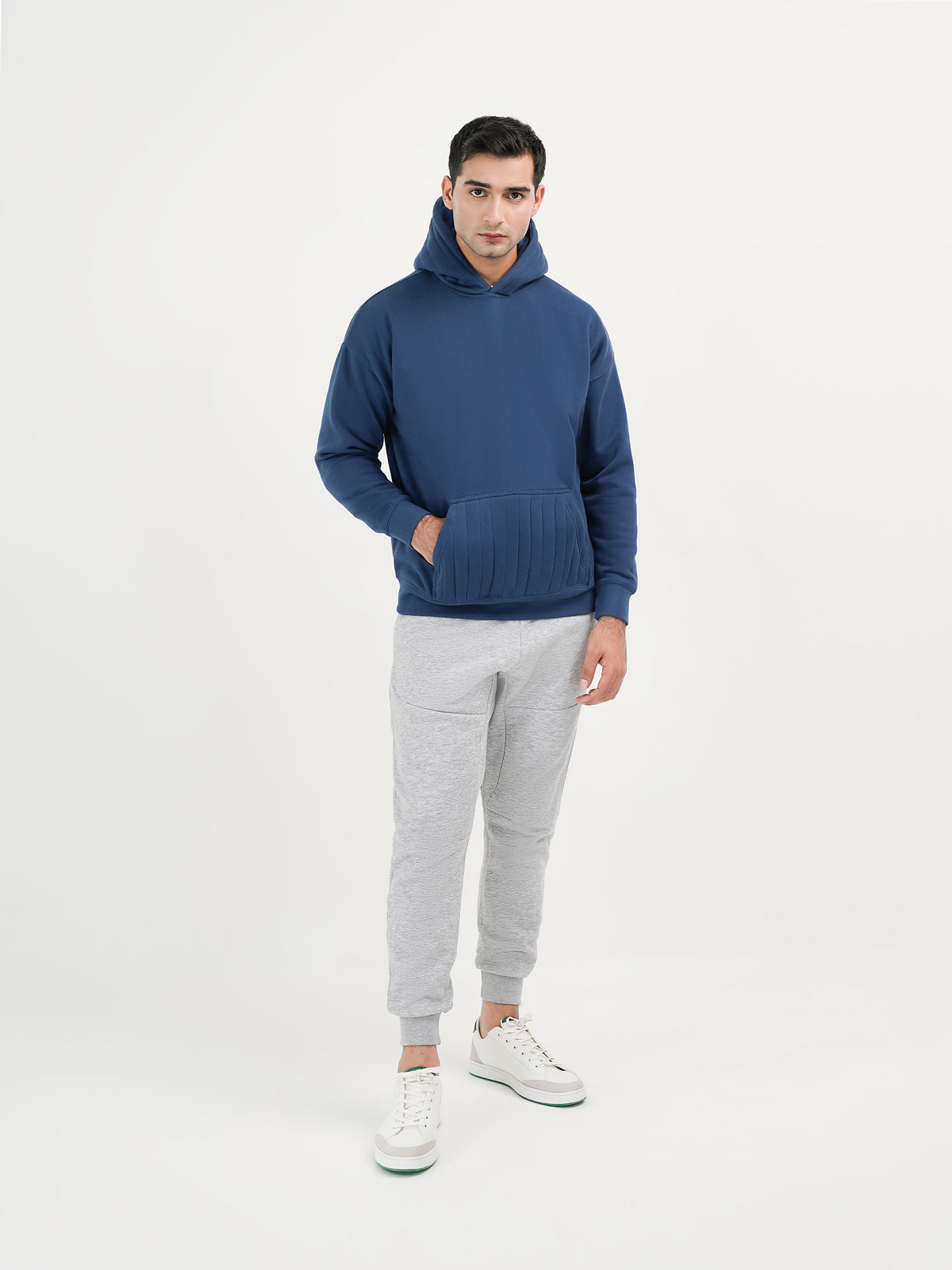 Man wearing a navy hoodie against a plain background