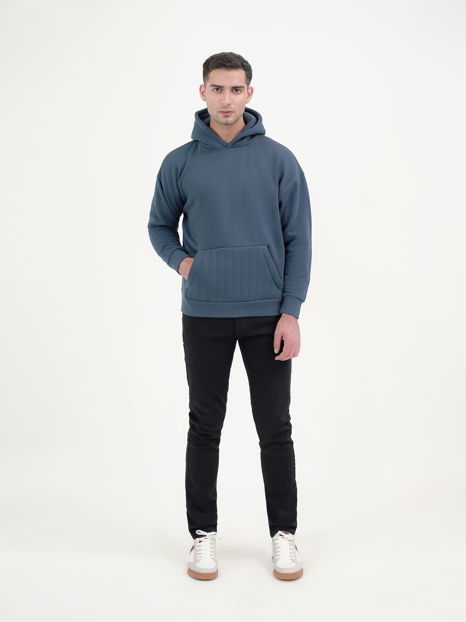 Man wearing a teal hoodie against a plain background