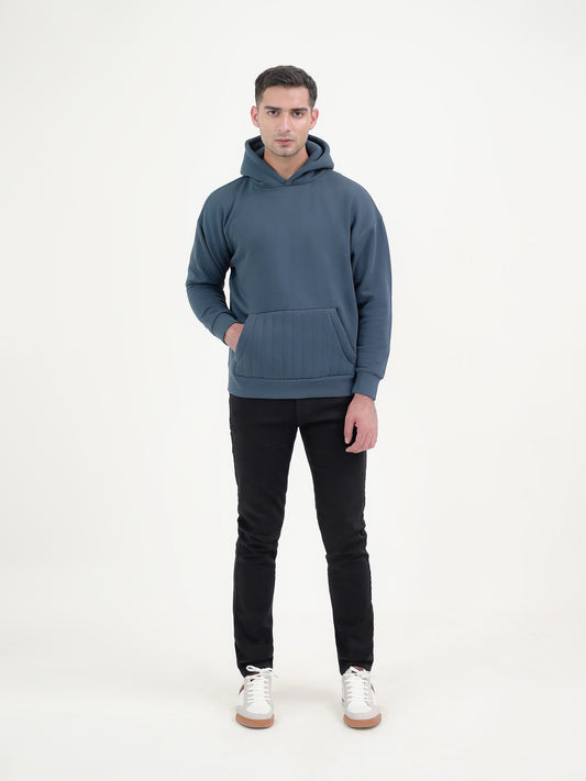 Man wearing a teal hoodie against a plain background