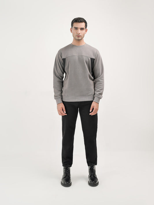 Man wearing a grey sweatshirt against a clean background