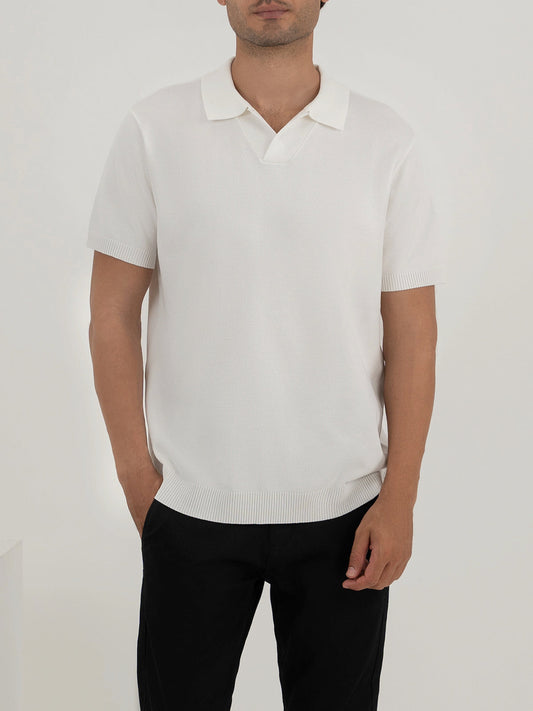 Man wearing a white polo shirt against a clean background