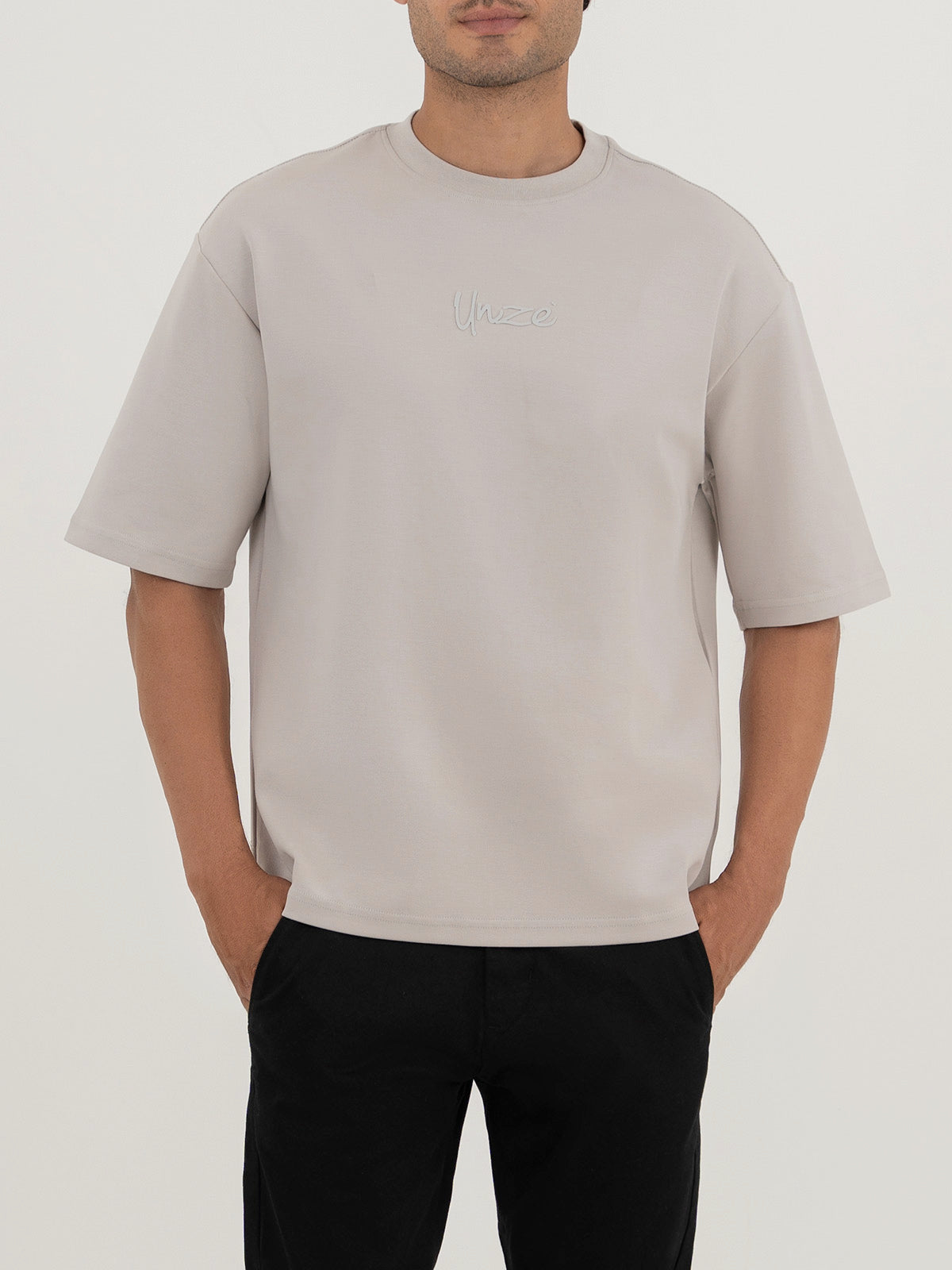 Man wearing an off-white t-shirt against a plain white background