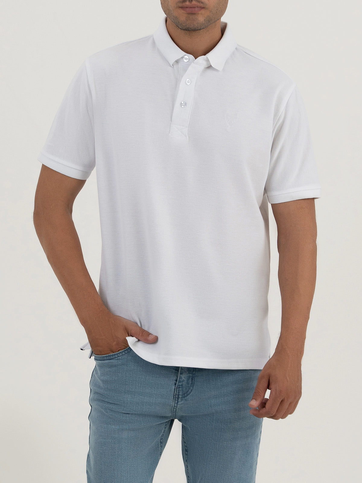 Man wearing a white polo shirt against a clean background