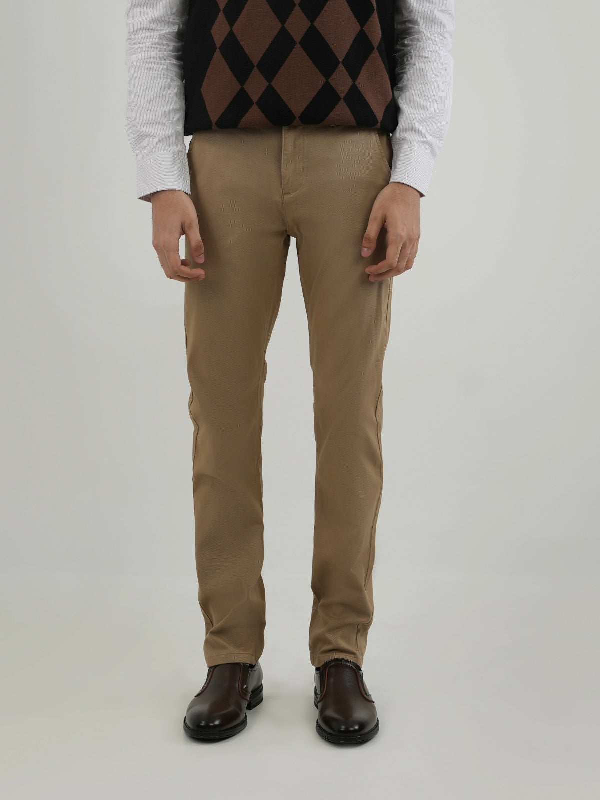 Man wearing a beige chinos against a clean background