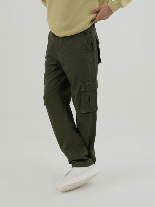 Man wearing an olive cargo trousers against a plain background