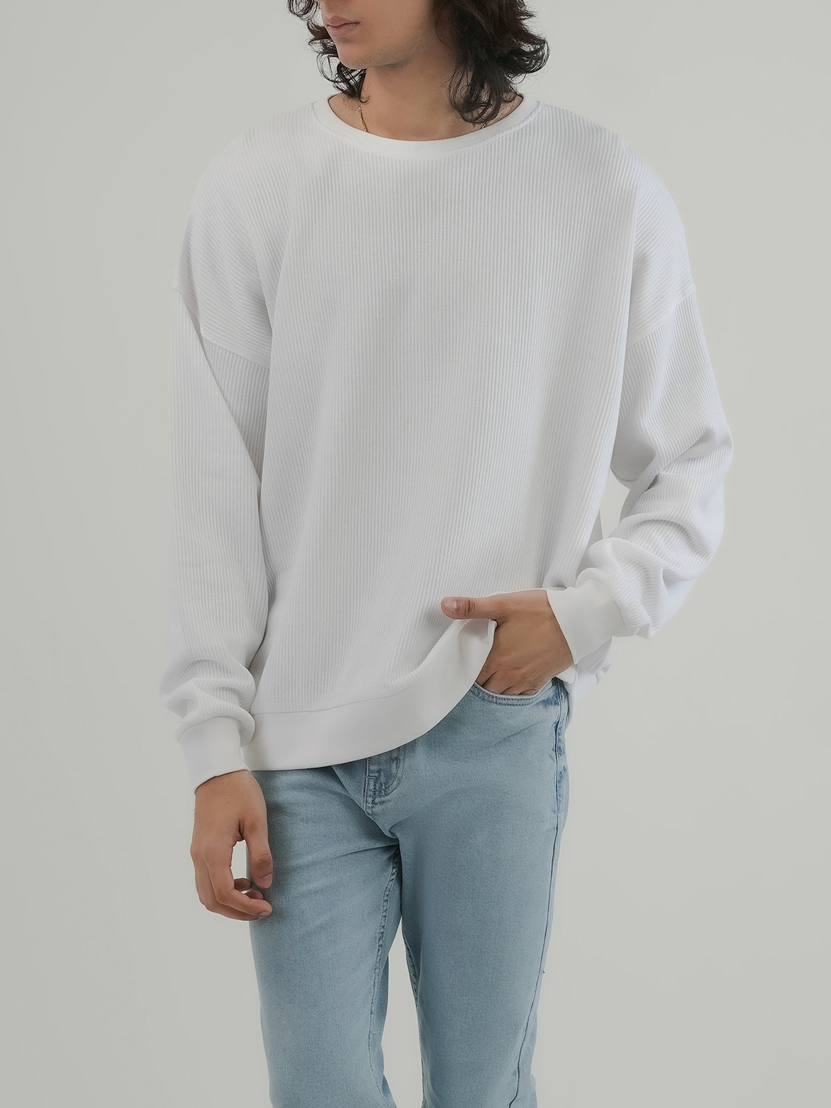 Man wearing a white sweatshirt against a clean background