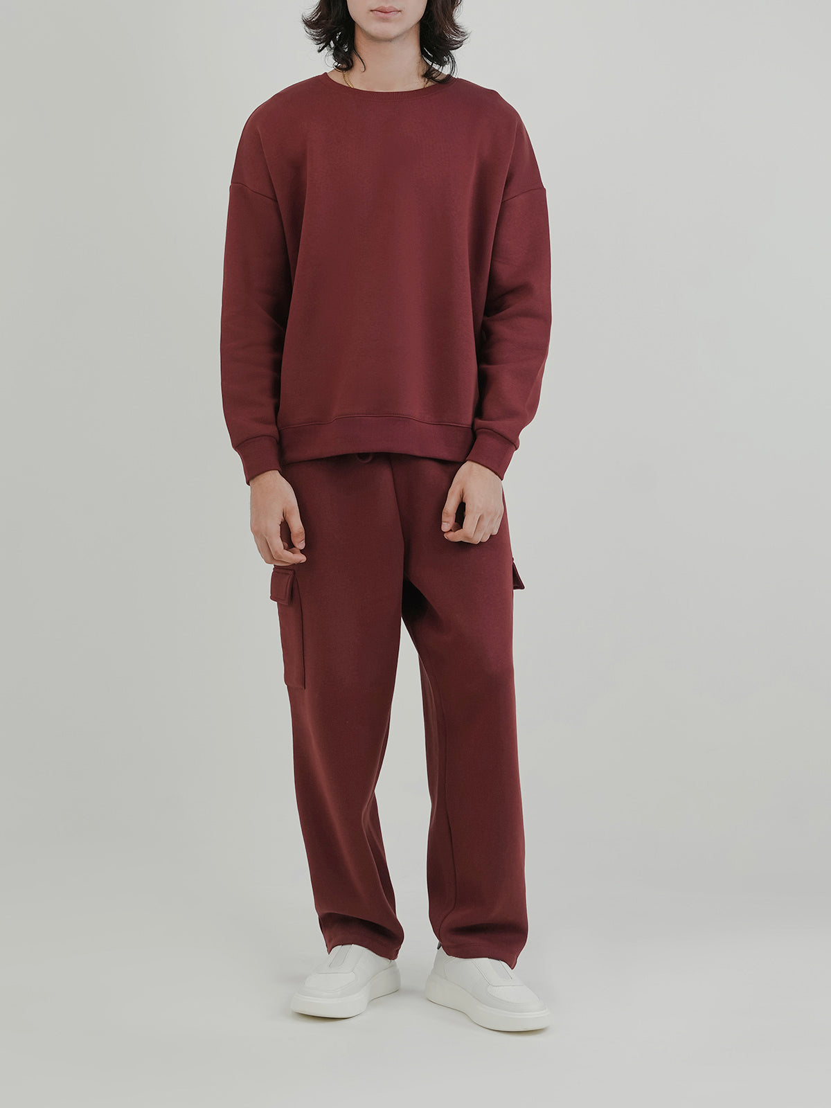 Man wearing a red tracksuit against a clean background
