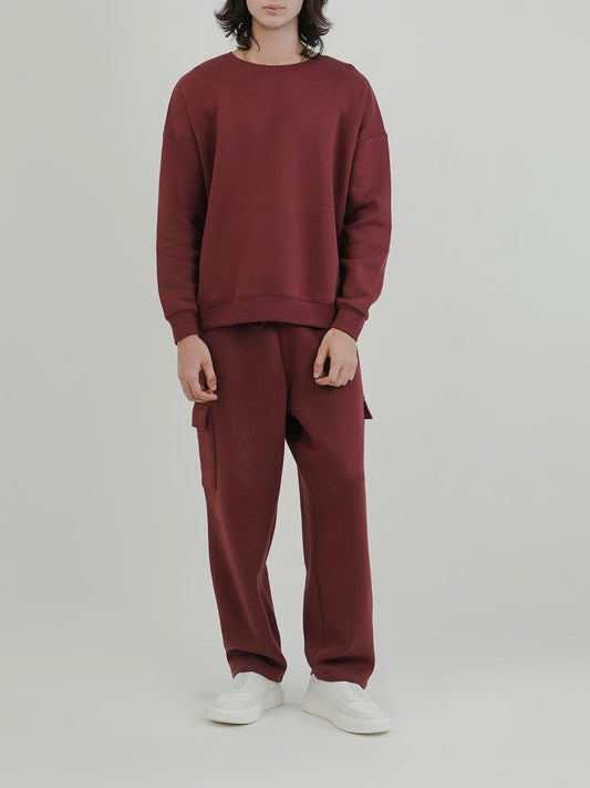 Man wearing a red tracksuit against a clean background