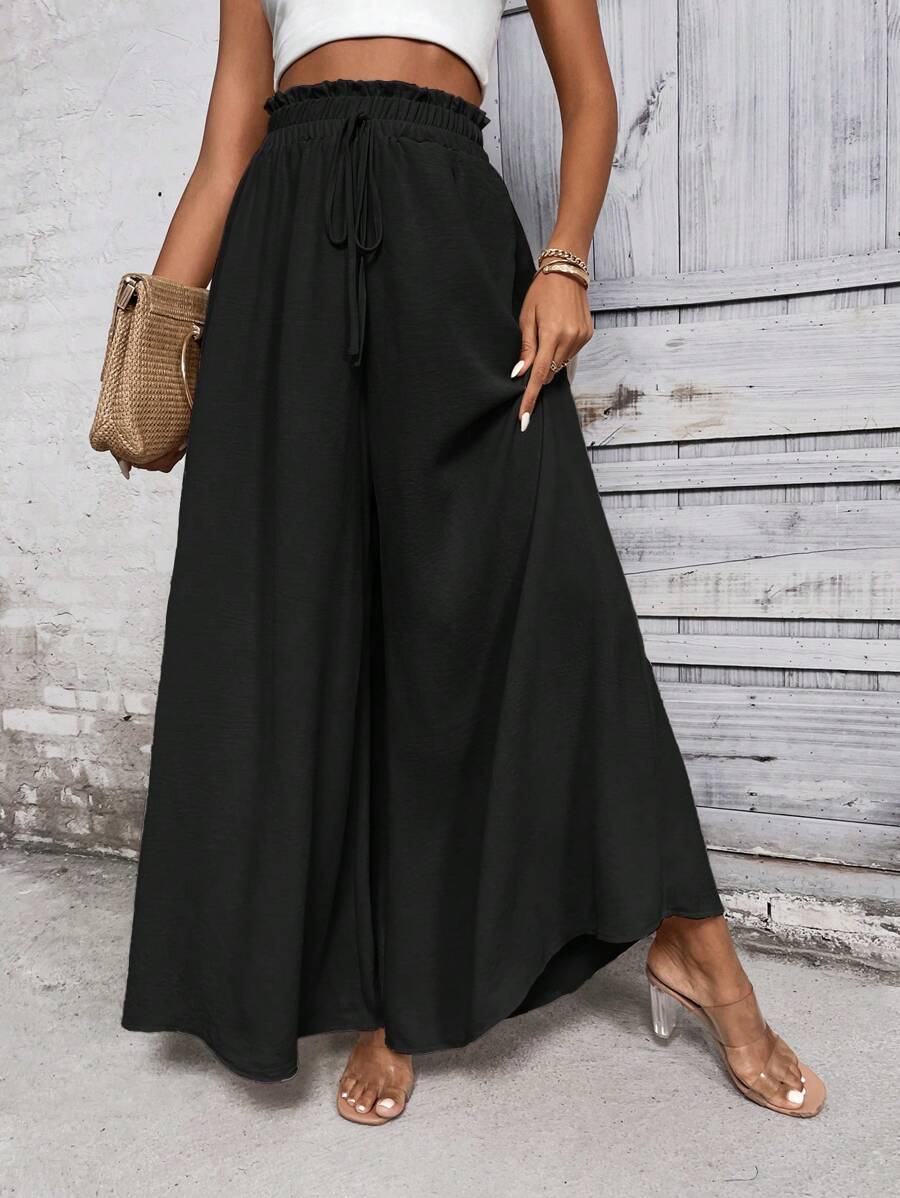 Woman wearing a wide-leg trousers against a plain background